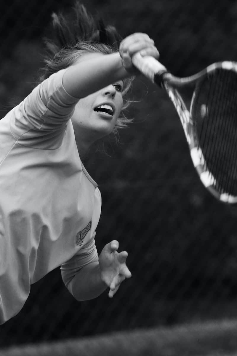 Grayscale Photo of Woman Playing Tennis