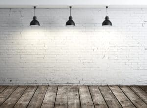 An Unoccupied Room With White Brick Walls And Wooden Flooring, Embellished With A Hint Of Green Yang Wood.